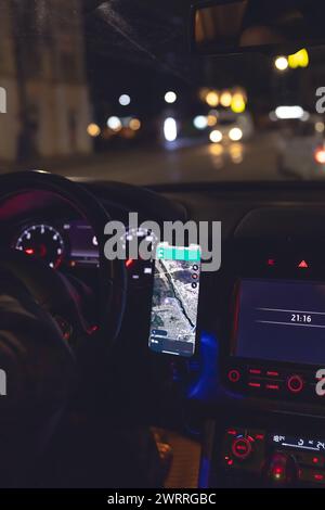 Navigator in einem Smartphone in einem Auto bei Nacht, Nahaufnahme. Stockfoto