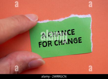 Eine Chance, Wörter zu ändern, geschrieben auf grünem zerrissenem Papier mit orangem Hintergrund. Konzeptsymbol. Kopierbereich. Stockfoto