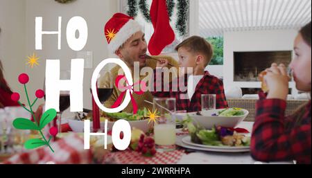 Bild von ho ho ho Text über der kaukasischen Familie, die weihnachtsmütze trägt Stockfoto