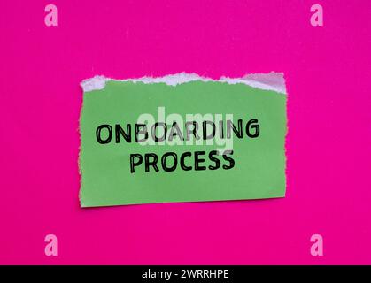 Wörter für den Onboarding-Prozess auf grünem, gerissenem Papier mit rosa Hintergrund. Konzeptionelles Geschäftssymbol. Kopierbereich. Stockfoto