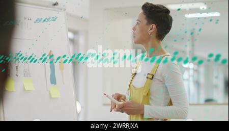 Bild der Datenverarbeitung über birassische Geschäftsfrau im Büro Stockfoto