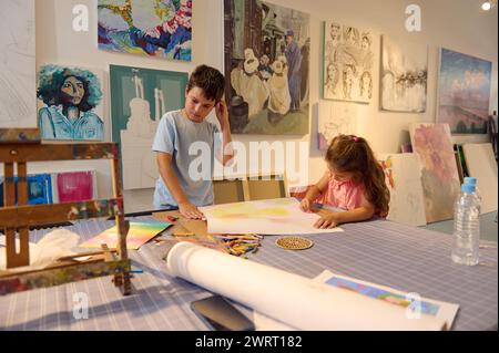 Zwei Kinder, die Kunst in der Kreativschule spielen. Selbstbewusstes Porträt eines kaukasischen Primarkindes, das ihr kreatives Hobby während der bildenden Kunst-cla genießt Stockfoto