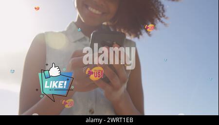 Bild: Folgen Sie uns über die Mitte einer glücklichen birassischen Frau, die draußen ein Smartphone benutzt Stockfoto