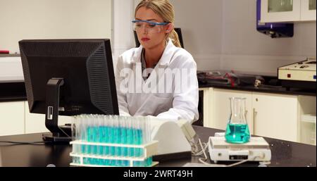 Bild von dna-Strang und menschlichem Gehirn über Wissenschaftlerin am Computer Stockfoto