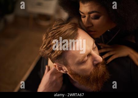 Leidenschaftliche Nacht mit verschiedenen Paaren zu Hause, lockige afroamerikanerin, die einen tätowierten Mann küsst Stockfoto