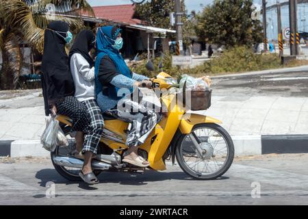 YALA, THAILAND, 01. März 2024, Eine Gruppe von Frauen in traditioneller Kleidung fährt zusammen auf einem Motorrad Stockfoto