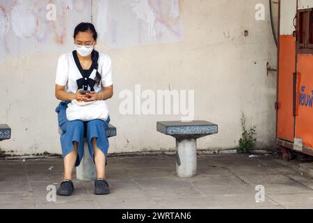 SAMUT PRAKAN, THAILAND, SEP 30 2023, Eine Frau wartet an einer Bushaltestelle Stockfoto