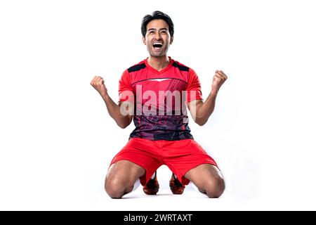 Junge Fußballspieler zeigen Spannung und Freude, nachdem sie gewonnen und erfolgreich gefeiert haben, stehen im Studio auf weißem Hintergrund. Stockfoto