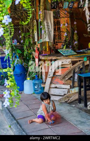 Kind spielt in einer Straßenszene in der Altstadt von Ko Lanta, baufällig, Stadt, Stadt, Live, Leben, asiatisch, Straße, exotisch, Tourismus, reisen, lang Stockfoto