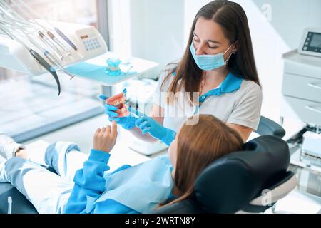 Facharzt in einer Zahnklinik unterrichtet eine Kinderzahnhygiene Stockfoto