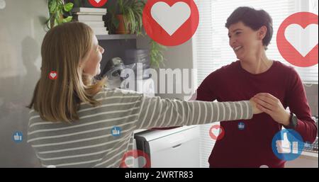 Ein Bild von Herzen und Ikonen über weißes weibliches Paar, das tanzt Stockfoto