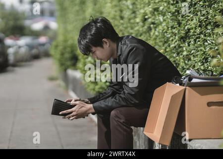 Mitarbeiter, die aus dem Unternehmen entlassen oder zurückgetreten sind, öffnen ihre Geldbörsen, haben aber kein Geld. Arbeitslos, Einstellung, Kündigung des Arbeitsplatzes Konzept. Stockfoto