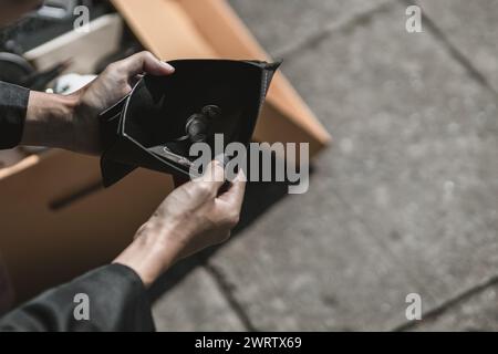 Mitarbeiter, die aus dem Unternehmen entlassen oder zurückgetreten sind, öffnen ihre Geldbörsen, um Münzen zu sehen. Arbeitslos, Einstellung, Kündigung des Arbeitsplatzes Konzept. Stockfoto