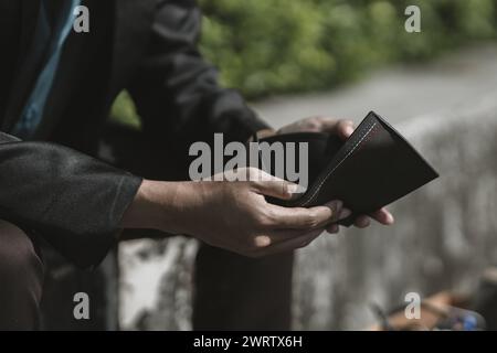 Mitarbeiter, die aus dem Unternehmen entlassen oder zurückgetreten sind, öffnen ihre Geldbörsen, haben aber kein Geld. Arbeitslos, Einstellung, Kündigung des Arbeitsplatzes Konzept. Stockfoto