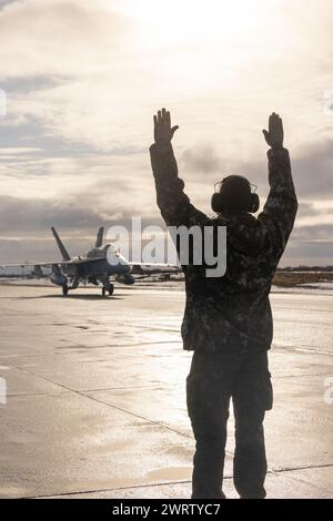 Ein Betreuer der finnischen Luftwaffe, rechts, liefert Hand-und-Arm-Signale an einen finnischen Luftwaffe F/A-18C Hornet-Piloten Stockfoto