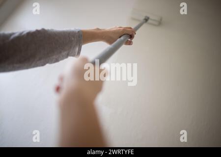 Berlin, Deutschland. Februar 2024. Eine Frau malt eine Wand in einem Zimmer weiß. Quelle: Sebastian Gollnow/dpa/Alamy Live News Stockfoto