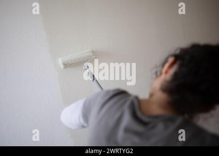 Berlin, Deutschland. Februar 2024. Eine Frau malt eine Wand in einem Zimmer weiß. Quelle: Sebastian Gollnow/dpa/Alamy Live News Stockfoto