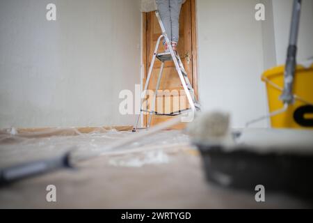 Berlin, Deutschland. Februar 2024. Eine Frau klebt eine Tür in einem Raum, bevor sie malt. Quelle: Sebastian Gollnow/dpa/Alamy Live News Stockfoto