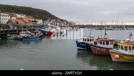 Kommerzielle Boote liegen im Hafen von Scarborough mit der Stadt dahinter in Yorkshire, England Stockfoto