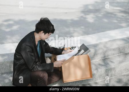 Mitarbeiter, die aus dem Unternehmen entlassen wurden oder aus dem Unternehmen entlassen wurden, schreiben ein Bewerbungsformular. Arbeitslos, Einstellung, Kündigung des Arbeitsplatzes Konzept. Stockfoto