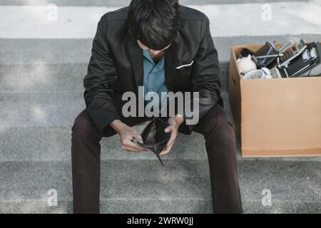 Mitarbeiter, die aus dem Unternehmen entlassen oder zurückgetreten sind, öffnen ihre Geldbörsen, haben aber kein Geld. Arbeitslos, Einstellung, Kündigung des Arbeitsplatzes Konzept. Stockfoto