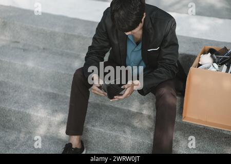 Mitarbeiter, die aus dem Unternehmen entlassen oder zurückgetreten sind, öffnen ihre Geldbörsen, haben aber kein Geld. Arbeitslos, Einstellung, Kündigung des Arbeitsplatzes Konzept. Stockfoto