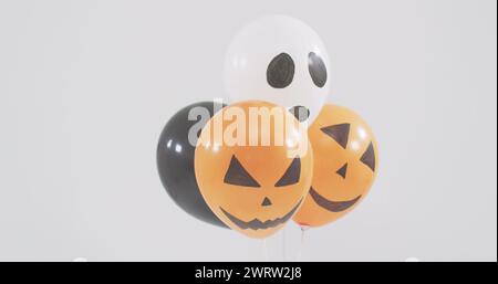 Bild von Happy halloween Text über Neonhexe und orange und schwarze Ballons Stockfoto