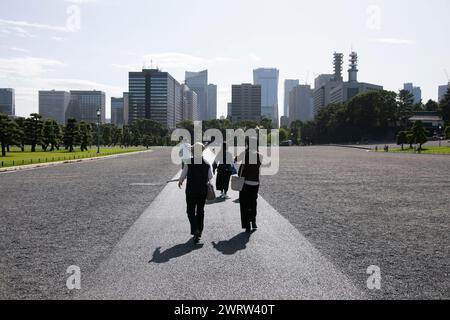 Eine Gruppe von Touristen, die durch den Kaiserpalast in Tokio, Japan, spazieren gehen. Stockfoto