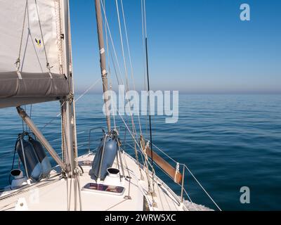 Segelboot segelt auf ruhigem Meer mit leichten Winden unter klarem blauem Himmel, Deutsche Bucht, Nordsee in der Nähe der Küste von Jütland, Dänemark Stockfoto