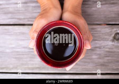 kaukasische Frau, die eine Tasse Kaffee von oben hält Stockfoto
