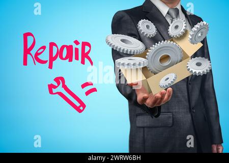 Geschäftsmann mit Karton gefüllt mit grauen Zahnrädern Stockfoto