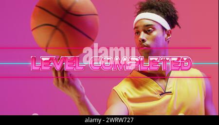 Bild des Textes, der auf dem Level abgeschlossen ist, über Neonmuster und birassischem Basketballspieler Stockfoto