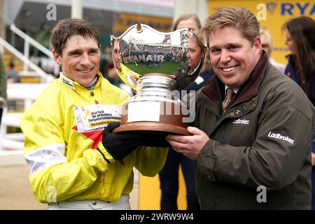 Jockey Harry Skelton (links) und Trainer Dan Skelton feiern mit der Trophäe, nachdem sie am dritten Tag des Cheltenham Festivals 2024 auf der Cheltenham Racecourse die Ryanair Steeple Chase mit Pferd Protektorat gewonnen haben. Bilddatum: Donnerstag, 14. März 2024. Stockfoto