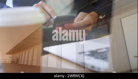 Bild eines Mannes, der im Hintergrund ein Smartphone über dem Lager verwendet Stockfoto