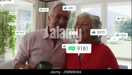 Bild von Social-Media-Ikonen und -Zahlen über Seniorenpaare zu Hause Stockfoto