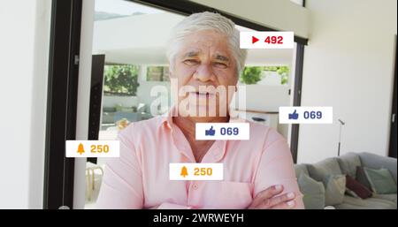 Bild von Social-Media-Ikonen und Zahlen über dem kaukasischen Mann zu Hause Stockfoto