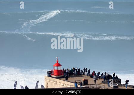 Portugal, Region Oeste, Nazaré, Surfer und Support Jet Skis fahren während des Free Surfing Events 2022 in der Nähe von Praia do Norte auf riesigen Wellen Stockfoto