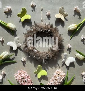 Wachtelfederkranz umgeben von Blumen und Schmetterlingen Stockfoto