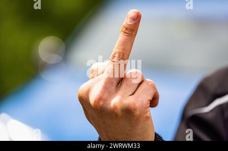 Der Stinkefinger ist eine bekannte, aber nicht freundlich, Geste. Hier von einem jungen Mann gezeigt. (Wil ZH, Schweiz, 20.05.2023) Stockfoto