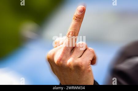 Der Stinkefinger ist eine bekannte, aber nicht freundlich, Geste. Hier von einem jungen Mann gezeigt. (Wil ZH, Schweiz, 20.05.2023) Stockfoto