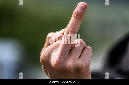 Der Stinkefinger ist eine bekannte, aber nicht freundlich, Geste. Hier von einem jungen Mann gezeigt. (Wil ZH, Schweiz, 20.05.2023) Stockfoto