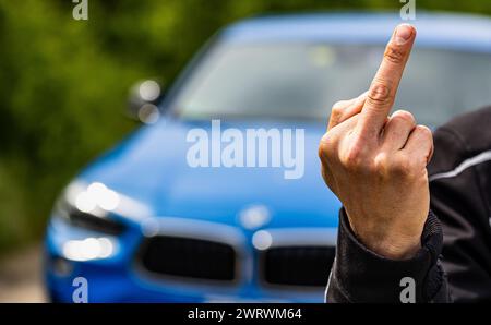 Der Stinkefinger ist eine bekannte, aber nicht freundlich, Geste. Hier von einem jungen Mann gezeigt. (Wil ZH, Schweiz, 20.05.2023) Stockfoto