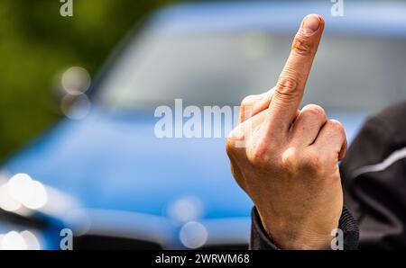 Der Stinkefinger ist eine bekannte, aber nicht freundlich, Geste. Hier von einem jungen Mann gezeigt. (Wil ZH, Schweiz, 20.05.2023) Stockfoto