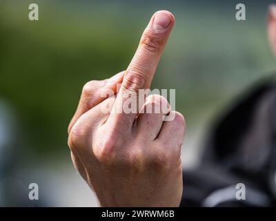 Der Stinkefinger ist eine bekannte, aber nicht freundlich, Geste. Hier von einem jungen Mann gezeigt. (Wil ZH, Schweiz, 20.05.2023) Stockfoto