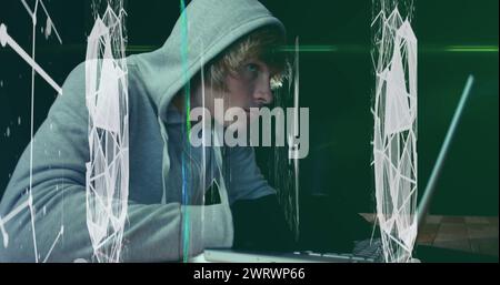Hacker in Hoodie verwendet Laptop mit schwebenden Formen auf grünem Hintergrund. Stockfoto