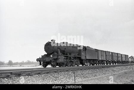 1950er Jahre, historisch, eine Dampflokomotive mit Güterwagen auf Eisenbahngleise, eine British Railways Stanier 8F 2-8-0 48436, England, UK. Stockfoto