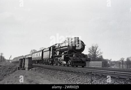 1950er Jahre, historische Dampflokomotive, eine Castle Class 4--6-0, auf einer Eisenbahnstrecke, A 35, die den Red Dragon betreibt, einen Personenzug von Camarthen, Wales nach London Paddington, England, Großbritannien. Die Lokomotiven der Castle-Klasse wurden 1923 und 1950 für die Great Western Railway (GWR) gebaut. Der Dienst wurde 1965 eingestellt. Stockfoto