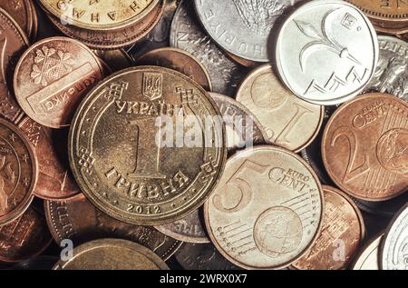 Foto einer Hrivna-Münze, die auf einem Stapel europäischer Münzen liegt. Nahaufnahme des Fotos. Stockfoto