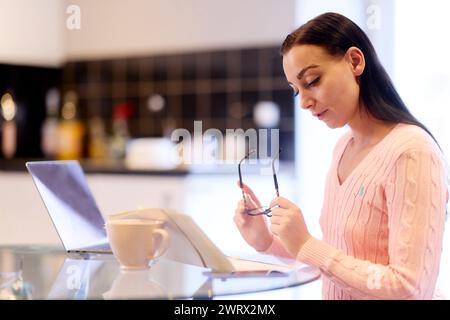 Frau, die zu Hause ihre Finanzen durchsucht Stockfoto