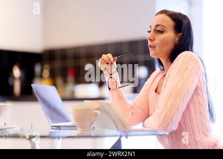 Frau, die zu Hause ihre Finanzen durchsucht Stockfoto